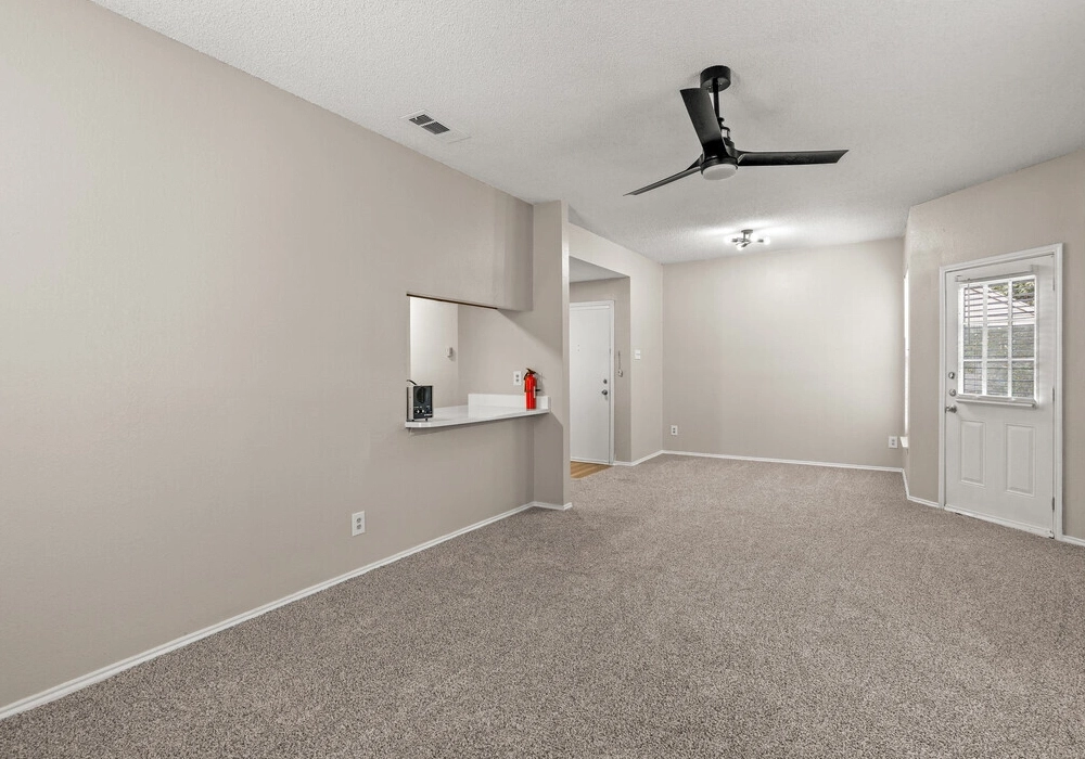 Carpeted living room and kitchen pass-through