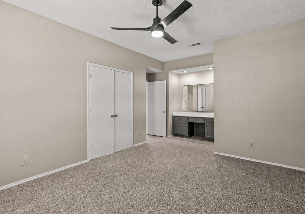 Carpeted bedroom with ensuite vanity
